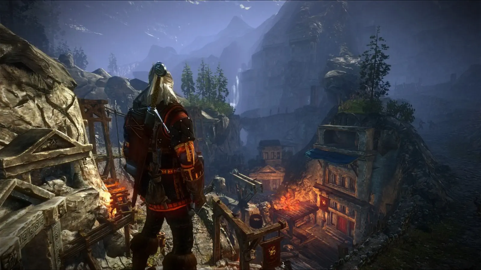 The Witcher 2: Geralt in a torch-lit mountain village at dusk