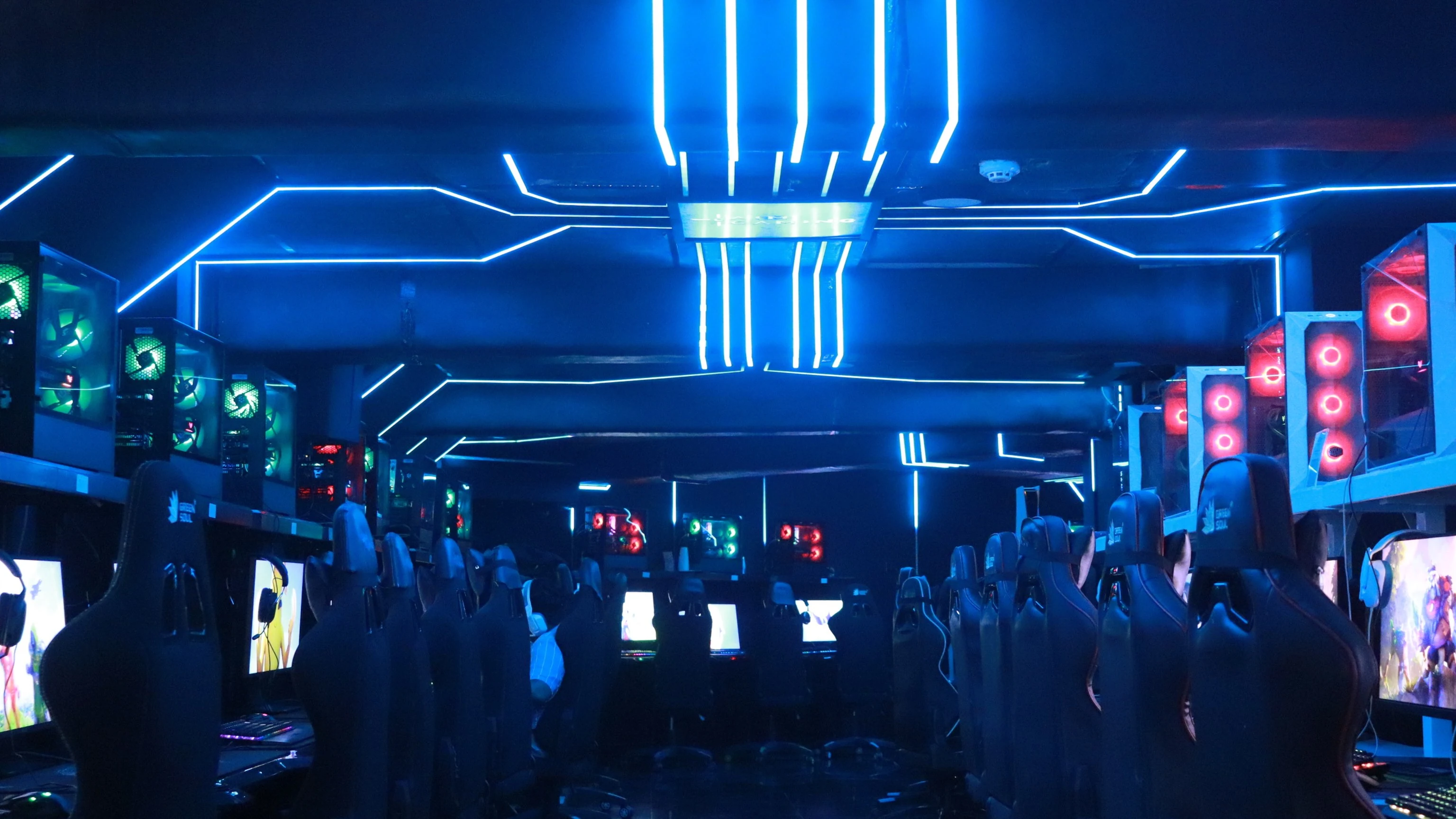 AIM Gaming Cafe Mumbai Review (2026): NVIDIA-Certified 24/7 Gaming 11 Rows of gaming PCs under blue neon lights at AIM Gaming Cafe, Mumbai