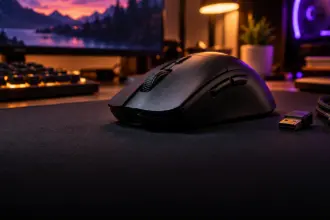 Ultralight black wireless gaming mouse on a cloth mouse pad with a small USB receiver, monitor glowing behind