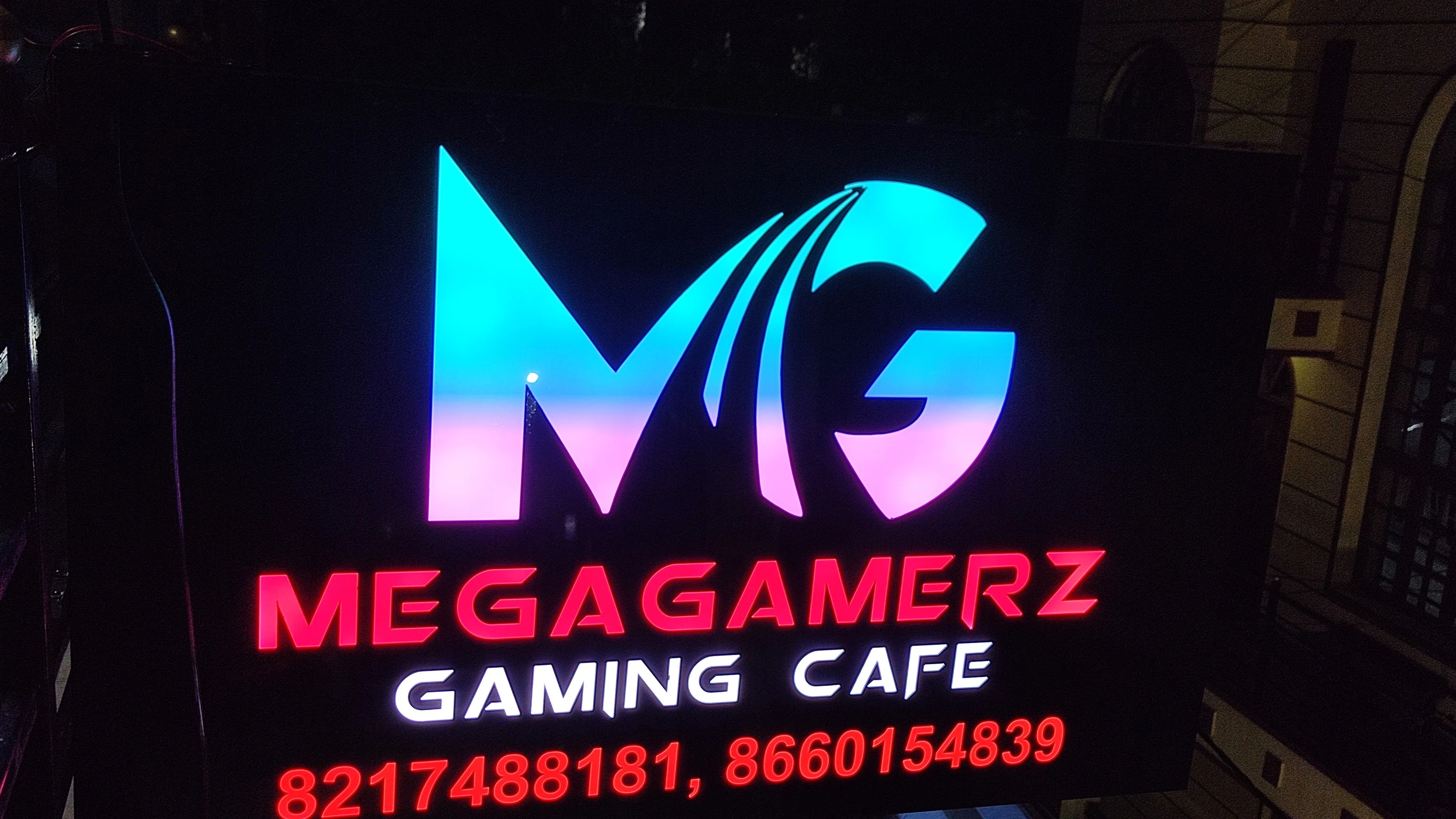 The lit MegaGamerz Gaming Cafe sign in Bengaluru at night