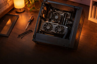 Budget PC lying open on a bedroom floor with a small graphics card just fitted