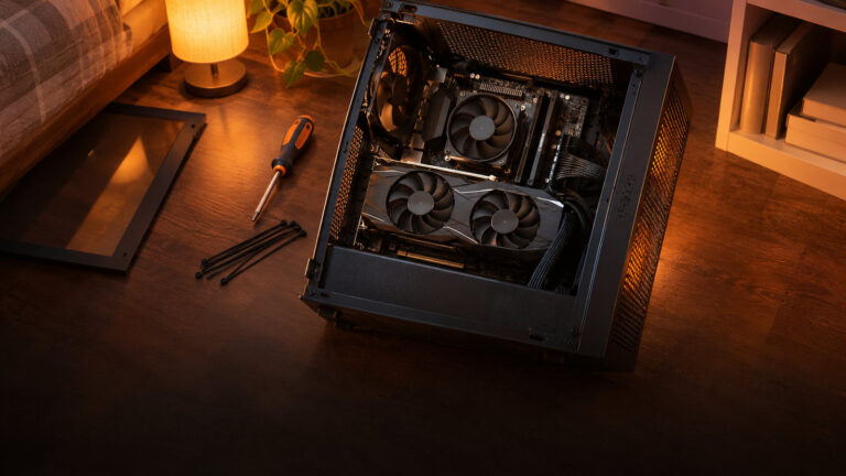 Budget PC lying open on a bedroom floor with a small graphics card just fitted