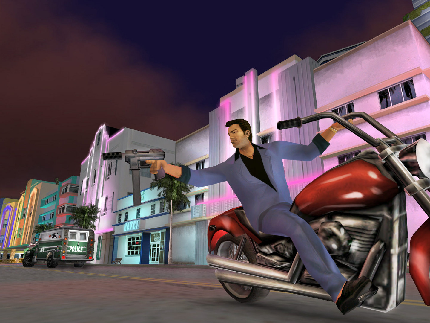 Tommy firing a pistol from a red motorbike past pink art deco buildings