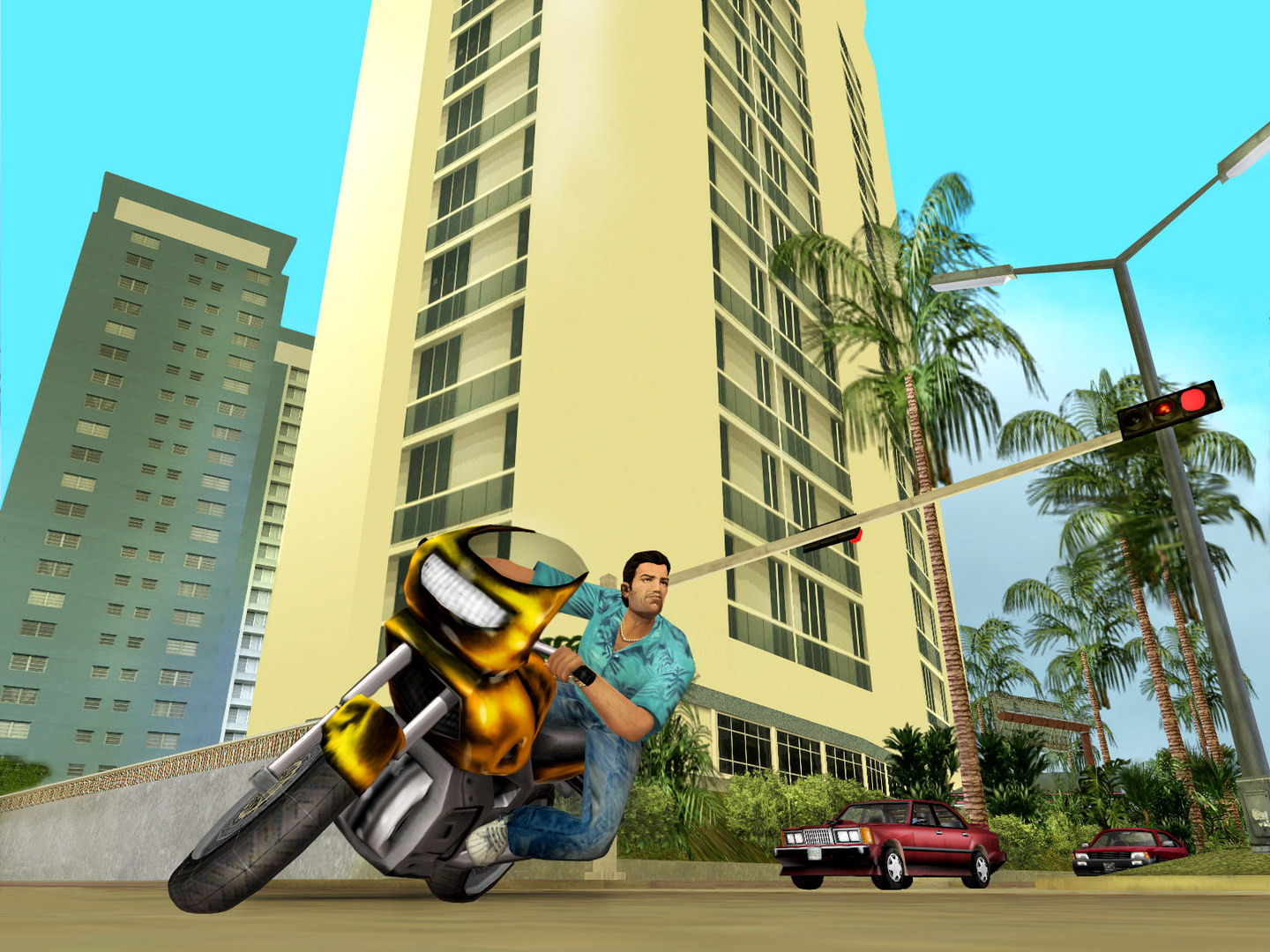 Tommy popping a wheelie on a yellow motorbike between tower blocks